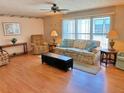 Inviting living room with floral sofa, wood floors, and lots of natural light at 11 Navel Dr, Winter Haven, FL 33884