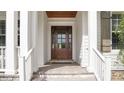 Elegant front door with glass panels, framed by white columns and a wood ceiling at 1162 E Highland Dr, Lakeland, FL 33813