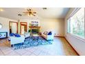 Bright living room features a stone fireplace, tile floors, and ample natural light from a large picture window at 1432 Libby Rd, Babson Park, FL 33827
