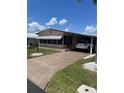 View of the home's exterior with a driveway and carport, showcasing its curb appeal at 148 Sweet Cir, Winter Haven, FL 33884