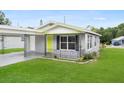 View of the home showcasing its inviting curb appeal with a well-kept lawn and carport at 2020 Bassedena W Cir, Lakeland, FL 33805