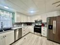 Modern kitchen featuring stainless steel appliances, stylish backsplash and sleek white cabinetry at 2055 S Floral Ave # 11, Bartow, FL 33830