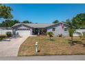 Attractive single-story home with a well-manicured lawn, a two-car garage, and a quaint front porch at 210 Citrus Dr, Winter Haven, FL 33884