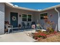 Inviting front porch with cozy seating, colorful flower pots, and a decorative wreath on the front door at 210 Citrus Dr, Winter Haven, FL 33884