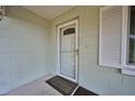 Cozy home entrance featuring a screen door and adjacent window with white shutters at 219 Willow St, Lake Wales, FL 33859
