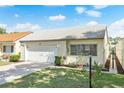 Charming single-story home with a well-maintained lawn, white tile roof and attached garage in a sunny neighborhood at 259 Mariposa, Winter Haven, FL 33884