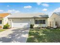 Charming single-story home with a white tile roof, well-maintained lawn, and attached one car garage at 259 Mariposa, Winter Haven, FL 33884