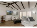 Bright living room features vaulted ceilings with dark wood beams, modern furniture, and hardwood floors at 259 Mariposa, Winter Haven, FL 33884