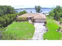 House with large lawn, mature trees, long driveway, and two-car garage at 2611 State Road 557, Lake Alfred, FL 33850