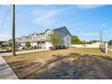 A street of modern townhomes with gray siding and well-manicured lawns under a clear blue sky at 310 N 1St Ave, Bartow, FL 33830