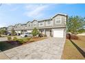 Row of modern townhomes showcasing gray siding, fresh landscaping, and paved driveways leading to attached garages at 310 N 1St Ave, Bartow, FL 33830