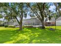 Backyard view of screen enclosed pool, boat, and nicely maintained green yard at 3826 Gaines Ct, Winter Haven, FL 33884