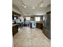 Open kitchen with stainless steel appliances, tile floors, and dark wood cabinets at 3851 Horizon View Loop, Lakeland, FL 33813