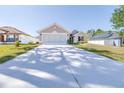 Lovely single-story home with a two-car garage, green lawn, and solar panels visible on the adjacent property at 404 Rio Grande Ct, Poinciana, FL 34759