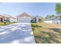 Beautiful one-story home with a wide driveway, manicured lawn, and charming architectural details at 404 Rio Grande Ct, Poinciana, FL 34759