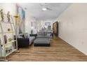 Spacious living room with hardwood floors, gray sectional, ceiling fan, and bright natural light at 4148 Dunmore Dr, Lake Wales, FL 33859