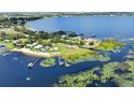 Aerial view showcasing the lakefront property with lush surroundings and private docks on the water at 553 Thornburg Rd, Babson Park, FL 33827