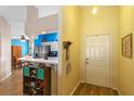 Inviting entryway with bright yellow walls leading to the kitchen and a view of the living spaces at 59 Saint Kitts Cir, Winter Haven, FL 33884
