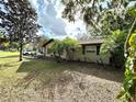 A charming home featuring mature landscaping with palms and trees in a large open yard at 605 Wanamaker Ave, Fort Meade, FL 33841