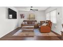 Cozy living room with a ceiling fan, large windows, and leather furniture at 608 William Ave, Winter Haven, FL 33880