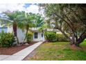 Welcoming front entrance with a walkway leading to a cozy home surrounded by mature landscaping at 612 Muskrat Dr, Kissimmee, FL 34759