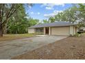 Exterior view of single-story home featuring a well-kept lawn and a concrete driveway at 6320 Newman E Cir, Lakeland, FL 33811