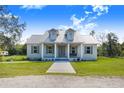 Charming single story home showcasing a welcoming front porch with columns and a manicured lawn at 6344 Old Lake Wilson Rd, Davenport, FL 33896