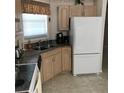 Functional kitchen featuring wooden cabinets, stainless steel sink, and modern appliances at 6398 Lolly Bay Ne Loop, Winter Haven, FL 33881