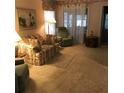 Comfortable living room with carpet, floral sofa, and bright natural light coming through the windows at 6398 Lolly Bay Ne Loop, Winter Haven, FL 33881