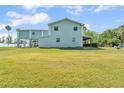 Expansive lawn with a two-story light blue home that has a metal roof and a covered porch at 6925 Alturas Babson Park Cutoff, Bartow, FL 33830