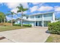 Charming two-story home with a metal roof, light blue siding and a long concrete driveway at 6925 Alturas Babson Park Cutoff, Bartow, FL 33830