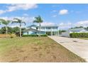 Stunning two-story home with a metal roof, light blue siding and a well-maintained lawn with palm trees at 6925 Alturas Babson Park Cutoff, Bartow, FL 33830