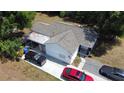 Aerial view of a single-story home with white siding and a concrete driveway with multiple cars parked at 730 Druid St, Lakeland, FL 33805