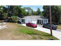 Charming single-story home with white siding, dark shutters and trim, and a concrete driveway with multiple cars parked at 730 Druid St, Lakeland, FL 33805