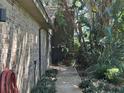 Brick home featuring a side walkway lush with greenery and manicured landscaping at 104 Woden Way, Winter Haven, FL 33884