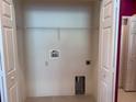 Inside laundry room closet with connections for washer and dryer, and overhead shelving at 1224 Vienna Square Dr, Winter Haven, FL 33884