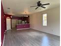 Open living area with wood floors, a ceiling fan, and seamless connection to the kitchen at 1224 Vienna Square Dr, Winter Haven, FL 33884