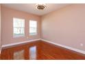 Cozy bedroom featuring hardwood floors, two windows, and a ceiling fan at 135 Eloise Oaks Dr, Winter Haven, FL 33884