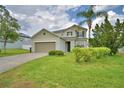 Well-kept two-story home with lush landscaping, a two-car garage, and a welcoming facade at 154 Canna Dr, Davenport, FL 33897