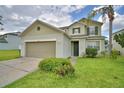 Lovely two-story home with manicured landscaping, a two-car garage, and a welcoming entrance at 154 Canna Dr, Davenport, FL 33897