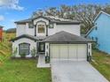 Charming two-story home featuring a two-car garage, manicured lawn, and beautiful dark and light exterior paint scheme at 157 Golf Aire Blvd, Haines City, FL 33844