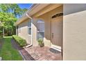Inviting covered front entrance featuring brick pavers, an arched window, and a classic-style door at 1573 Vienna Square Dr, Winter Haven, FL 33884