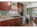 Well-lit kitchen with dark cabinets, stainless steel appliances, and tile countertops at 1610 Reynolds Rd # 242, Lakeland, FL 33801