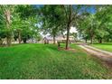 Lush backyard with mature trees and green lawn, offering privacy and natural beauty at 1646 Tyner Rd, Haines City, FL 33844