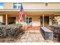 Inviting front porch with tile flooring, cozy seating, and an American flag at 1646 Tyner Rd, Haines City, FL 33844
