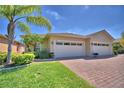 Charming home with a three-car garage, lush landscaping, and brick driveway at 1674 Linz Ct, Winter Haven, FL 33884