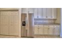 Modern kitchen with stainless steel refrigerator, white cabinets, and granite counters at 1674 Linz Ct, Winter Haven, FL 33884