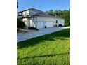 Spacious 3-car garage with ample parking on an extra-long driveway, complemented by lush green lawn at 177 Costa Loop, Auburndale, FL 33823