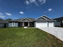 Charming single-Gathering home with a well-kept lawn, brick accents, and a paved driveway under a blue sky at 1781 Lakehill Dr, Winter Haven, FL 33884
