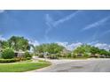 Community entrance with manicured landscaping, signage, and a security gate at 186 Viola Dr, Auburndale, FL 33823